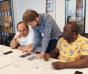 Porträt eines Mädchens mit Trisomie 21, das in einer Online-Unterrichtsstunde in die Kamera winkt.